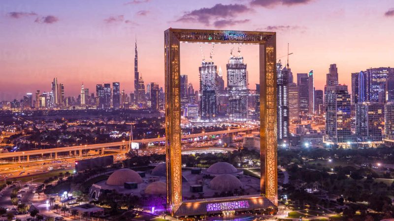 Aerial view of Dubai Frame, an iconic building in Dubai downtown with city skyline in background during a beautiful sunset, United Arab Emirates.