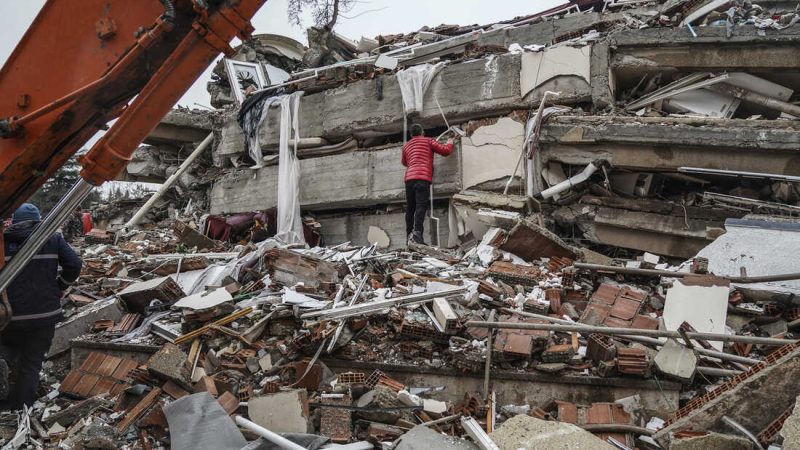 A man searches for people  in the rubble of a destroyed building in Gaziantep, Turkey, Monday, Feb. 6, 2023. A powerful quake has knocked down multiple buildings in southeast Turkey and Syria and many casualties are feared. (AP Photo/Mustafa Karali)